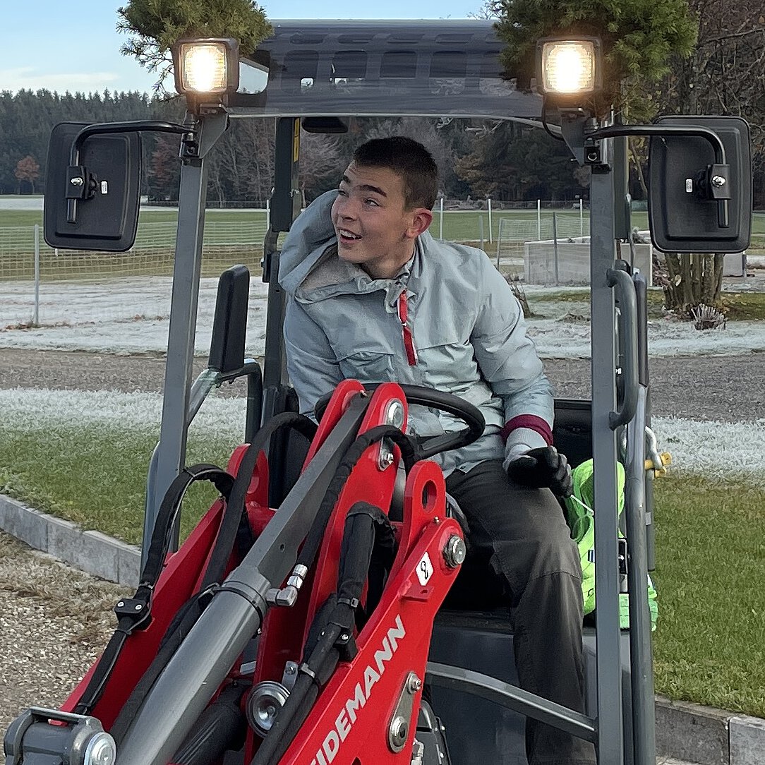 Simon sitzend im Hoflader
